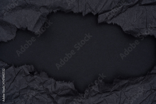 Torn Black Paper Revealing Dark Background.