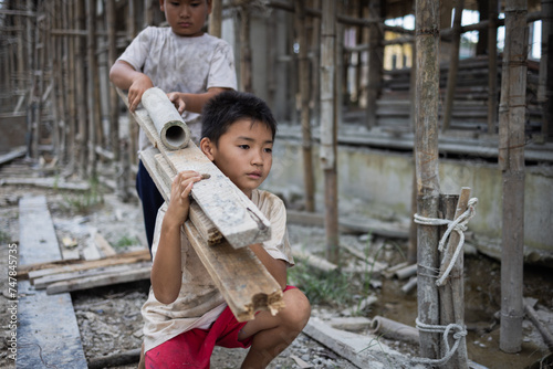 Poor boy working on a construction site. anti child labor Abuse, oppression or coercion, forced child labor Human trafficking. 4K slow motion. photo