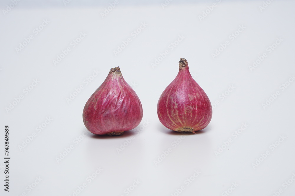 Fototapeta premium some raw red onions flat angle on a white background