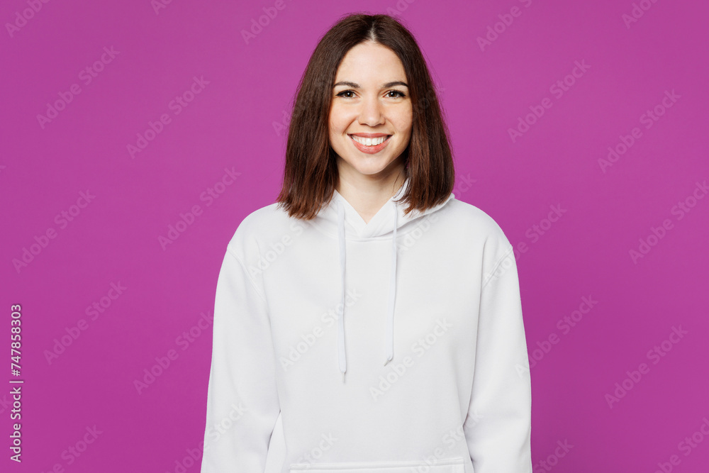 Young cheerful satisfied smiling happy Caucasian woman she wear light hoody casual clothes looking camera with toothy smile isolated on plain purple wall background studio portrait. Lifestyle concept. Young cheerful satisfied smiling happy Caucasian woman she wear light hoody casual clothes looking camera with toothy smile isolated on plain purple wall background studio portrait. Lifestyle concept.