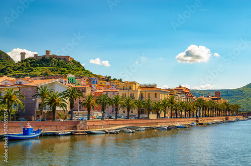 Picturesque view of Bosa town along Temo River in Sardinia, Italy, with colorful buildings and palm trees