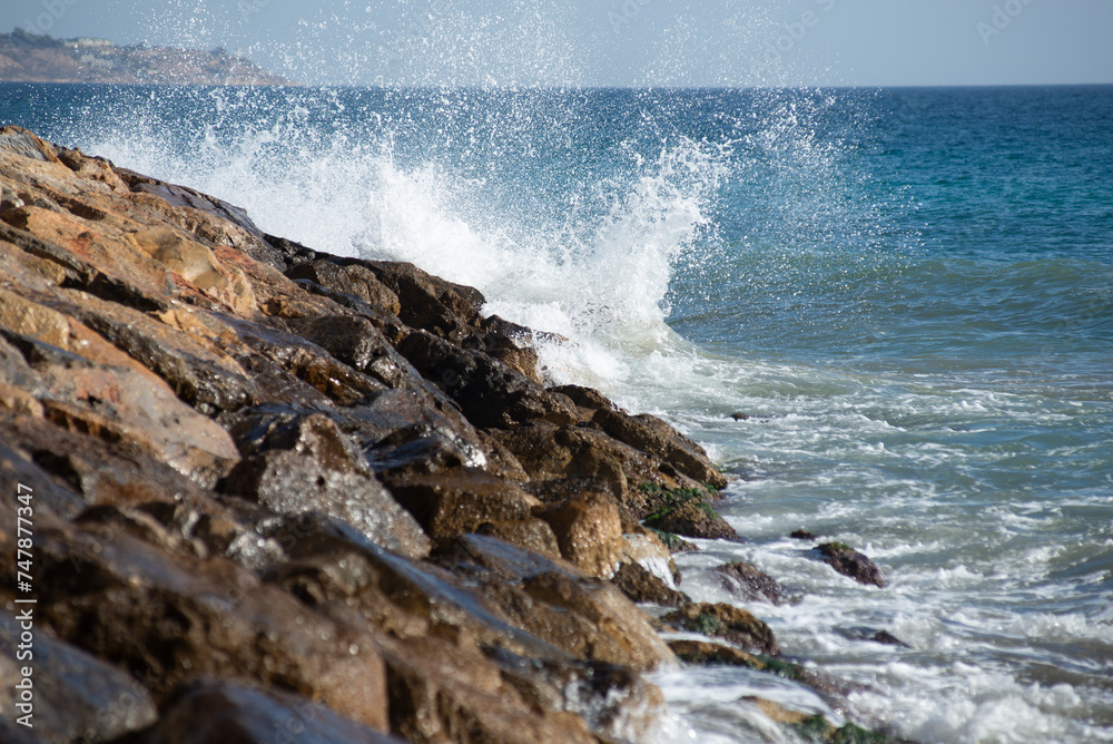 Waves crashing on the rocks in the mediterranean sea at sunset, turquoise water, white foam Waves crashing on the rocks in the mediterranean sea at sunset, turquoise water, white foam
