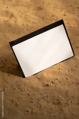 White blank tablet on the sand. Free space for text or logo. Natural colors.