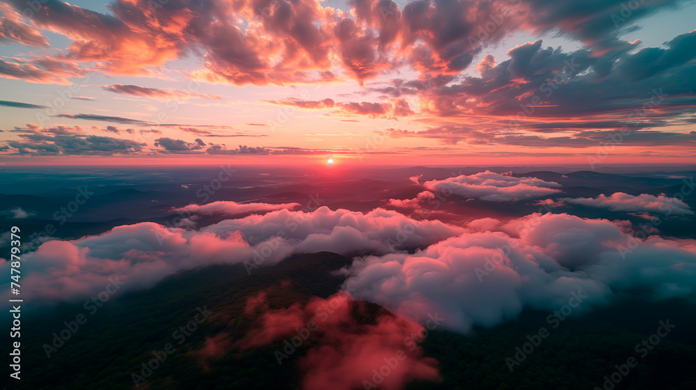 Aerial view of a breathtaking sunset over mountains, with clouds and warm skies, from a pilot's perspective.	