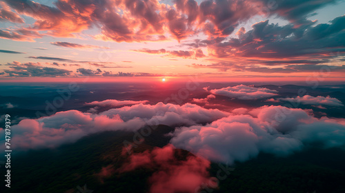 Aerial view of a breathtaking sunset over mountains, with clouds and warm skies, from a pilot's perspective. 