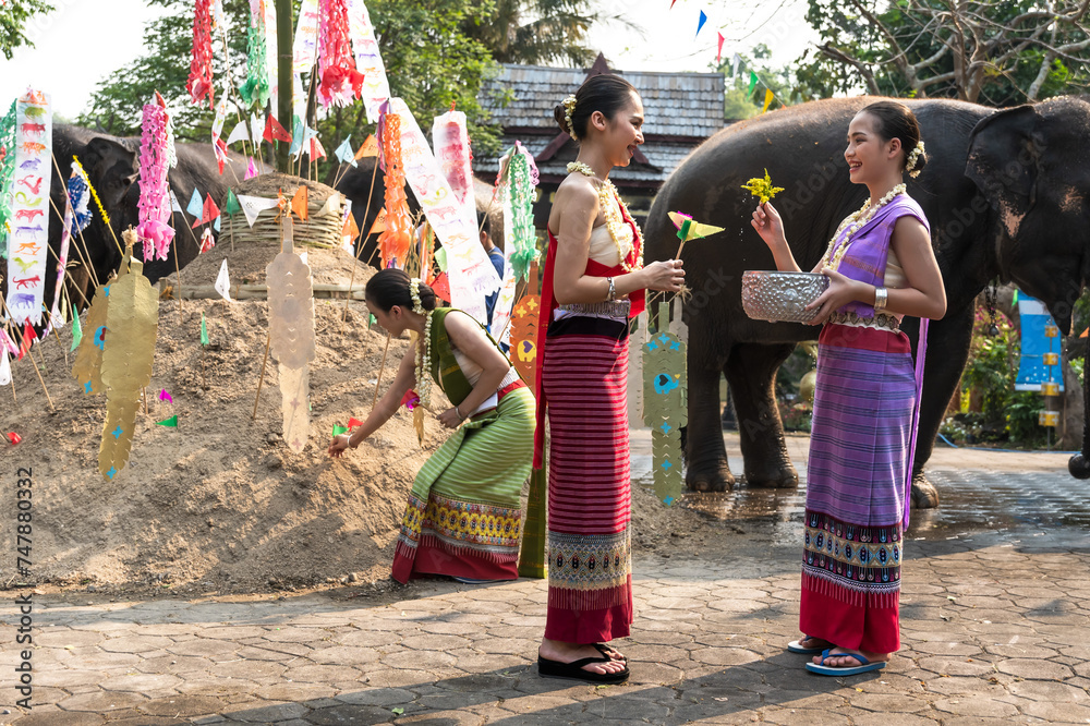 Naklejka premium Thai women in traditional Thai costumes gathering Song Kran festival in chiangmai , Thailand