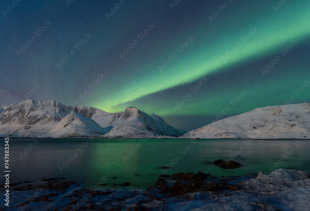 Aurora borealis, northern light over snowy mountains in winter