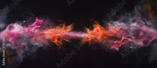 The vibrant hues of pink and orange burst forth against the stark black backdrop, creating a striking contrast. The explosion of colors fills the space with energy and intensity, drawing the eye to