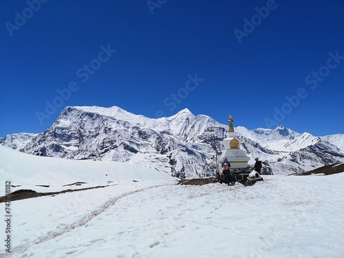 Buddhist monastery on atop a snow-covered mountain, rugged and alone, surrounded by breathtaking beauty and a sense of serenity. photo