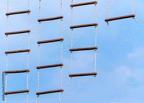 Fotografi rope ladder against a blue sky and clouds