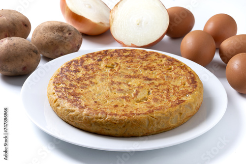 Traditional spanish omelette and ingredients isolated on white background
