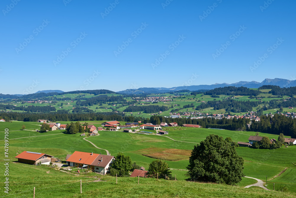 Alpine Foothills Charm: Rural Mountainside Living with Farmer's Homesteads. Mountain Countryside: Farmer's Dwellings, Pastures, and the Sky Above. Nature's Eco-Friendly Living in the Alpine Highlands