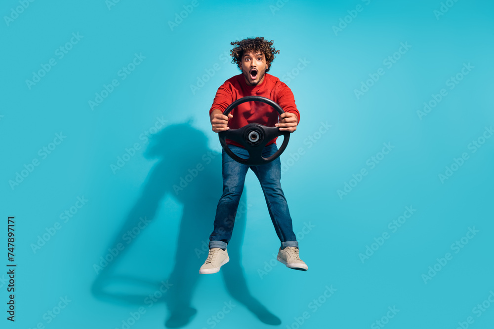 Full length size photo of crazy arabian guy driving automobile jump with steering wheel new golf gti car isolated on blue color background