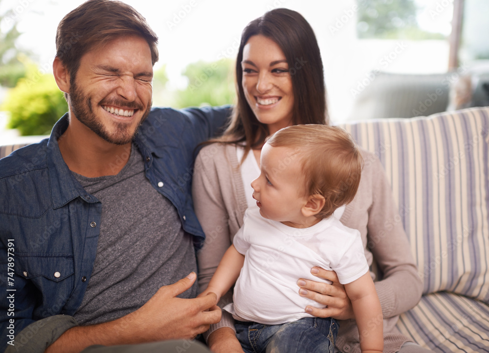 Happy family, smile and relax in sofa mother, father and child at home together. Married couple, parents and playing with baby boy for laughing, bonding and embrace relationship in living room
