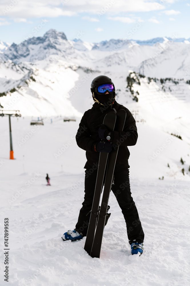 the athlete holds skis. portrait of a male skier at the top of the piste. ski resort. extreme sport. active winter holiday