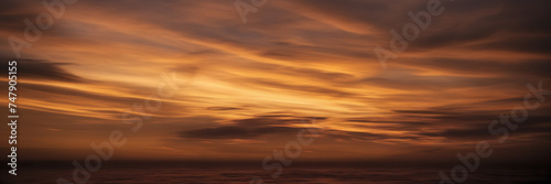 Photograph showcasing the dynamic interplay of golden and coppery smoke against a backdrop of twilight hues. © Hans