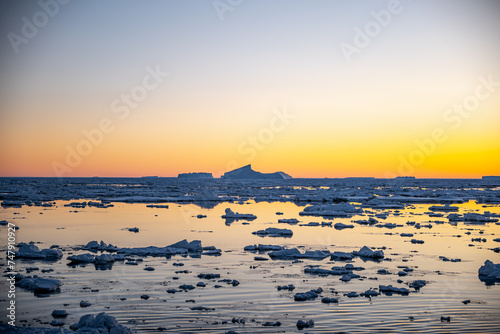 Sunset over sea ice and iceberg in Antarctica © David