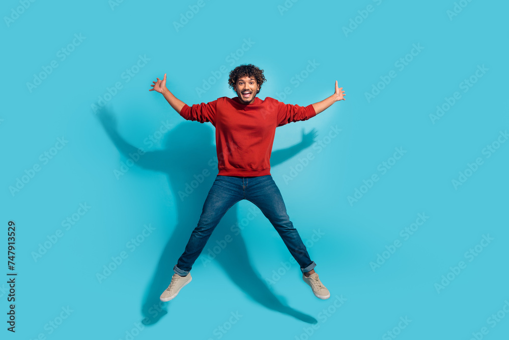 Full body size photo of overjoyed energetic mexican man jumping raised arms up in star shape isolated on aquamarine color background