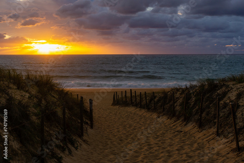 Sunset over sand and ocean with a cloudy sky. High quality photo