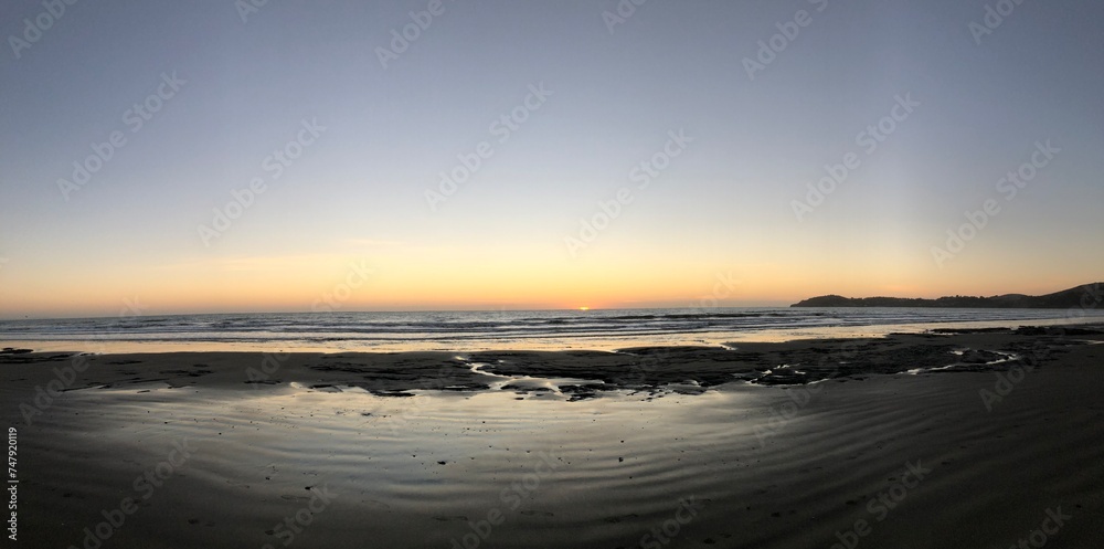 Sunset beach scene with sand and ocean waves