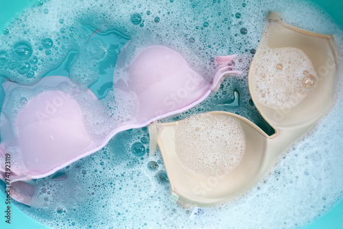 Bild auf Leinwand Lady bra soaked in water dissolved detergent with white foam bubble