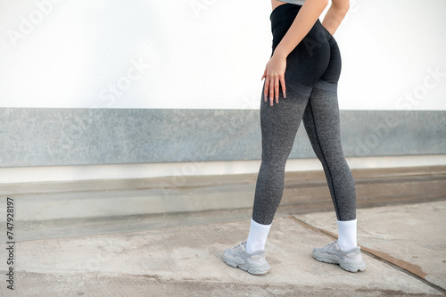 Girl with beautiful sporty bump, hips. Close up. Gray leggings. Health concept, workout, lifestyle, weight control, diet. Copy space. Body part. Front view.