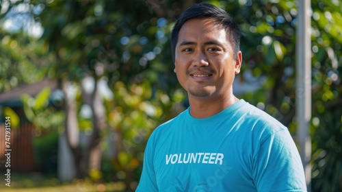 Man in blue volunteer shirt smiling at camera.