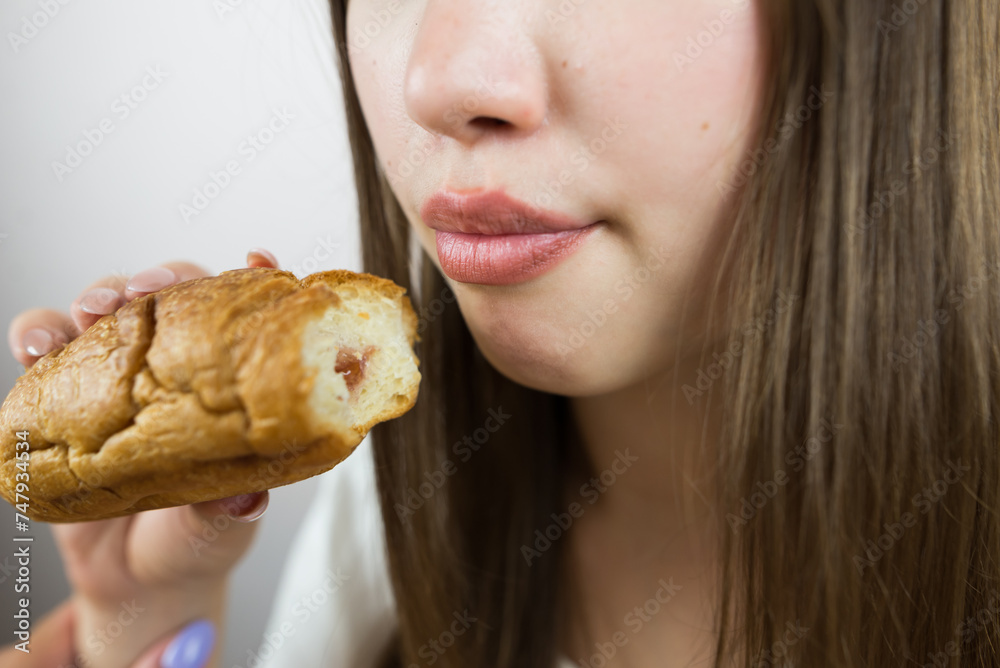 young beautiful girl eating a croissant, close-up, crop photo. female mouth eating croissant young beautiful girl eating a croissant, close-up, crop photo. female mouth eating croissant