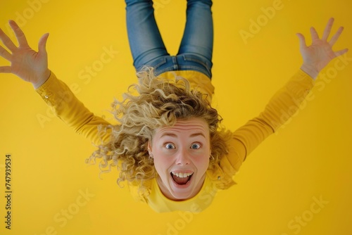 A woman with curly hair hanging upside down. Suitable for fitness or flexibility concept