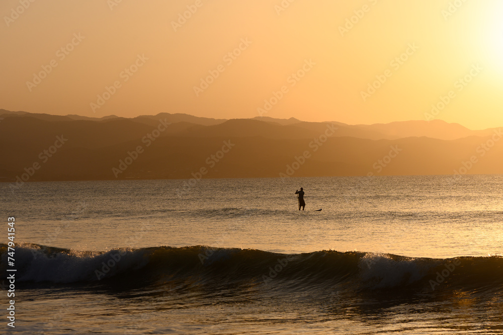 SUP boarding lesson on the Mediterranean sea in winter at sunset 3