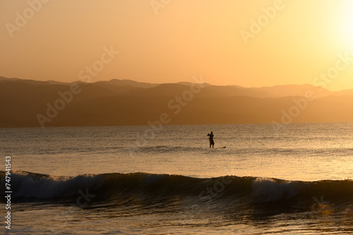 SUP boarding lesson on the Mediterranean sea in winter at sunset 3