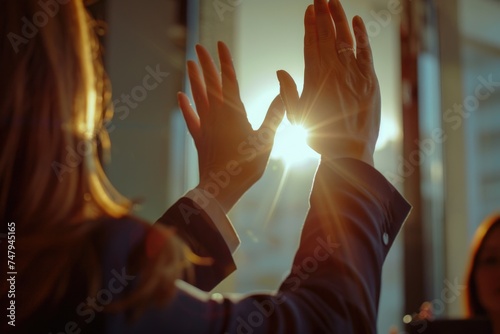 Woman raising hands in front of the sun. Suitable for spiritual and motivational concepts photo