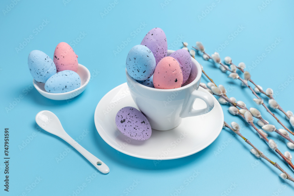 Cup with colored Easter eggs on the blue background. Cup with colored Easter eggs on the blue background.