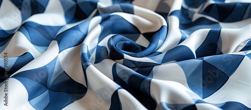 This close-up showcases a detailed view of a silk blue and white crepe fabric with a geometric print. The intricate patterns and textures of the fabric are highlighted in this image.