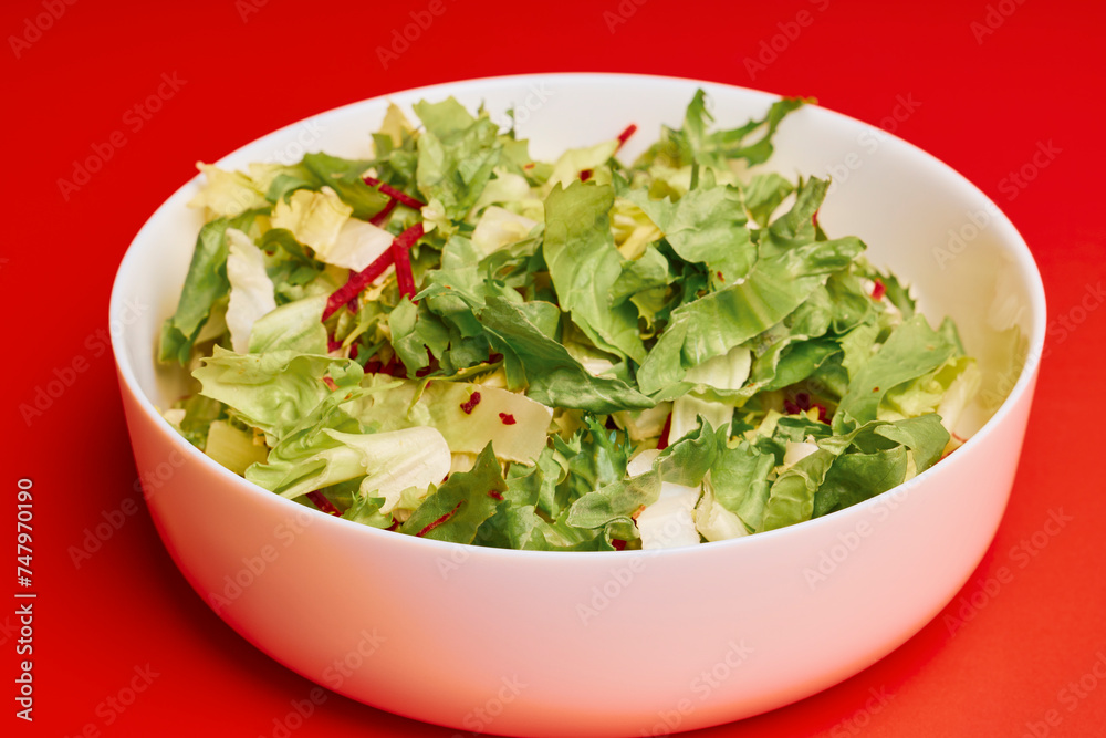 mixed green salad in a bowl on a red background mixed green salad in a bowl on a red background