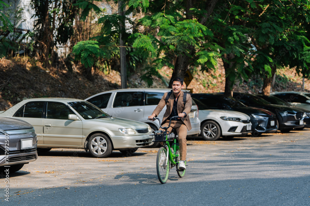 Elegant entrepreneur in smart casual cycling on bicycle track in warm sunny day area of city