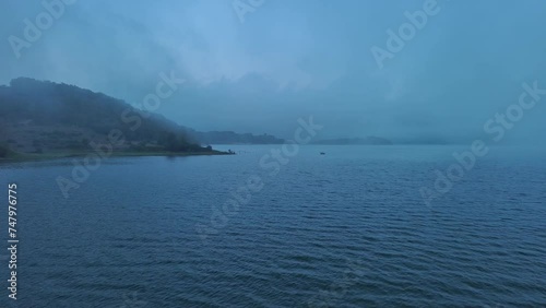 Misty morning at Nanclares de Gamboa lake, Basque Country, with serene waters and subtle sun rays photo