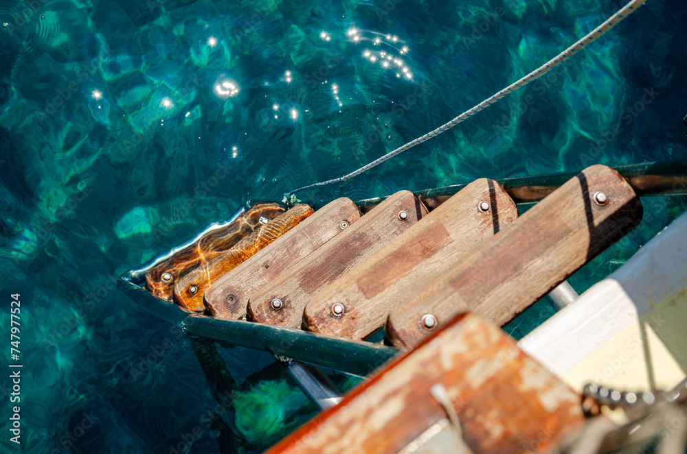 Wooden staircase of the boat sailing on blue water
