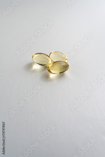 Three Vitamin D3 pills on a white background, promoting health and well-being. Perfect image for advocating a healthy lifestyle.