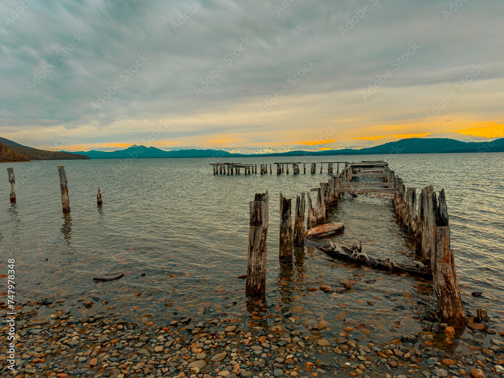 Old wooden pier on the lake on a beautiful sunset in the mountains