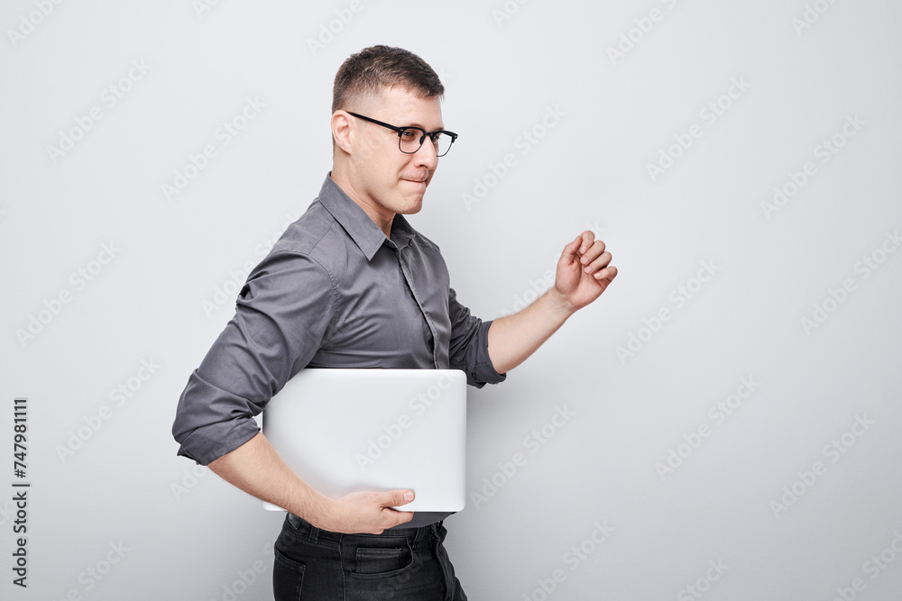 Joyful businessman manager programmer holds a laptop in his hands and smiles on a white background. Joyful businessman manager programmer holds a laptop in his hands and smiles on a white background.