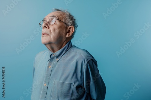 an old man wearing glasses and looking up