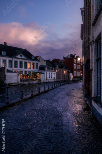 Solitary street by the canals of Bruges, after a rainy evening