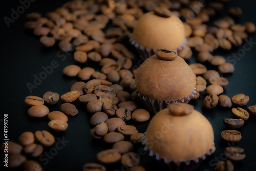 Um brigadeiro de café delicadamente disposto em uma base de forminha marrom, adornado com grãos de café, em meio a uma decoração. A coffee brigadeiro delicately arranged in a brown base.