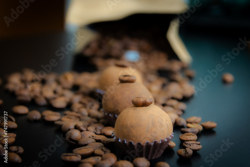 Um brigadeiro de café delicadamente disposto em uma base de forminha marrom, adornado com grãos de café, em meio a uma decoração. A coffee brigadeiro delicately arranged in a brown base.