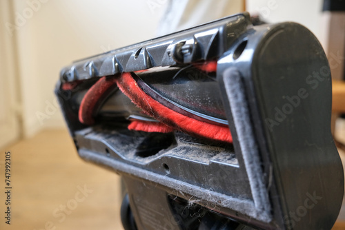 Bottom view of an upright vacuum cleaner head, with rotating brush. 