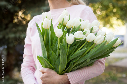 girl holding white tulips close-up
