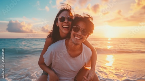 Asian Couple piggy back ride on sunset beach, travel and fun 