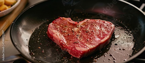 A heart-shaped striploin steak sizzling on a hot skillet, surrounded by spices and herbs, being cooked to perfection for two people.