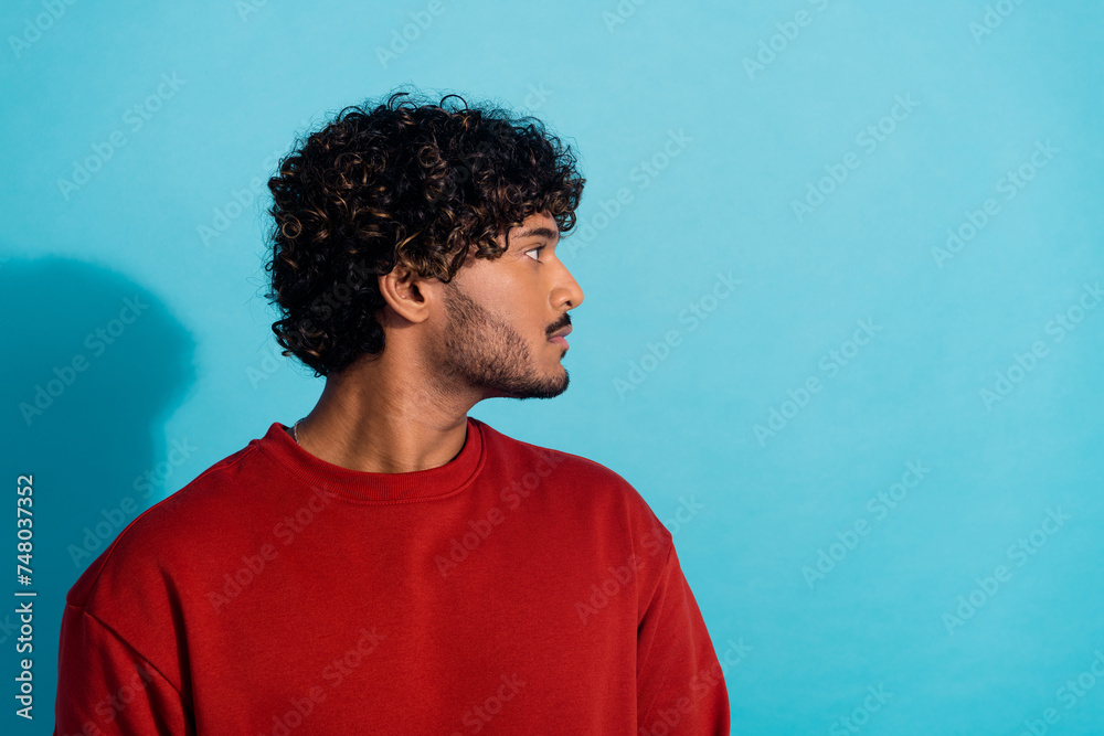 Profile portrait of focused concentrated young man calm face look empty space isolated on blue color background Profile portrait of focused concentrated young man calm face look empty space isolated on blue color background